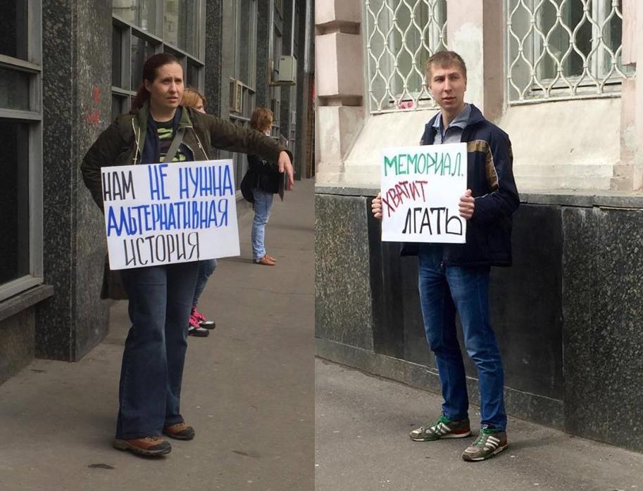 Two protesters outside the venue of an award ceremony with posters that read “We do not need alternative history” and “Memorial, stop lying”, April 28, 2016, Moscow. 