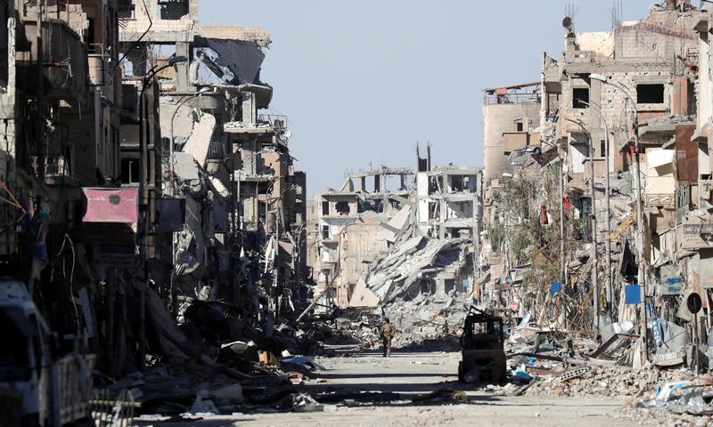 A fighter stands amidst the ruins of buildings near the Clock Square in Raqqa, Syria October 18, 2017. Picture taken October 18, 2017.