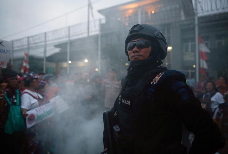 Seorang petugas polisi berjaga-jaga selama unjuk rasa yang dilakukan oleh para pendukung Gubernur Jakarta Basuki Tjahaja Purnama, alias Ahok, di luar Penjara Cipinang tempat ia dibawa menyusul vonis dalam kasus penodaan agama di Jakarta, Indonesia, 9 Mei 