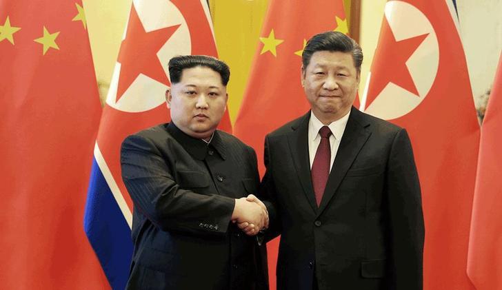2018년 3월 28일 평양의 조선중앙통신이 보도한 이 촬영날짜 미상의 사진에서 중국에 비공식 방문한 북한 지도자 김정은이 베이징에서 중국 시진핑 국가주석과 악수하고 있다.