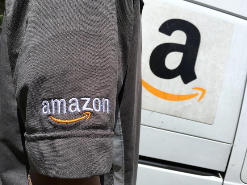 An Amazon.com Inc driver stands next to an Amazon delivery truck in Los Angeles, California, U.S., May 21, 2016.
