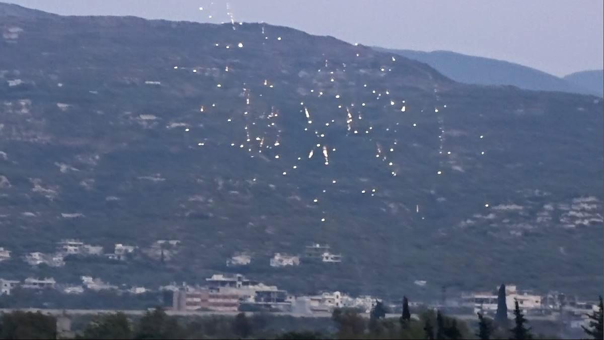 Incendiary rockets rain fire over farmland outside a town in western Idlib, Syria, on July 30, 2018. 