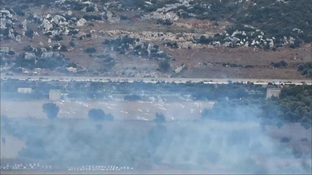 As flames from incendiary rockets rain down, smoke billows over farmland in western Idlib, Syria, on July 30, 2018. 