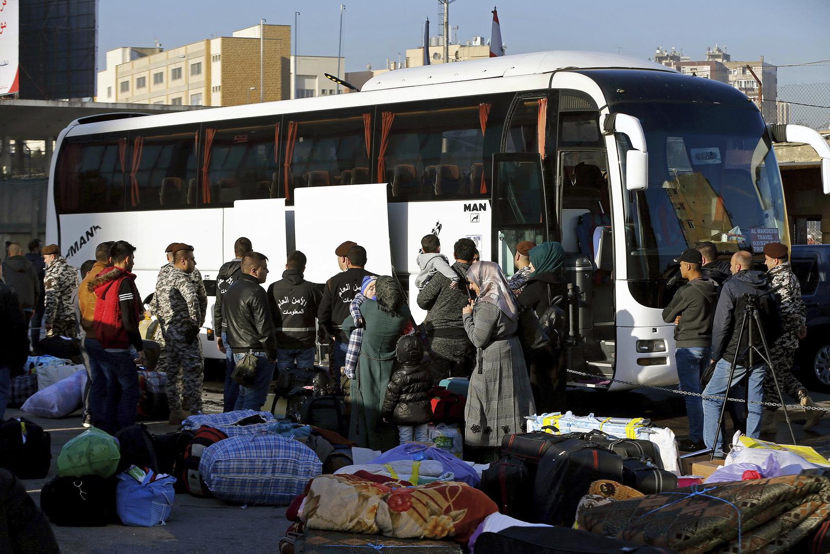 عناصر من المديرية العامة للأمن العام في لبنان يشرفون على لاجئين سوريين يستقلون حافلة ستنقلهم إلى ديارهم في سوريا. برج حمود، ضاحية بيروت الشمالية، لبنان، الخميس في 24 يناير/كانون الثاني 2019.