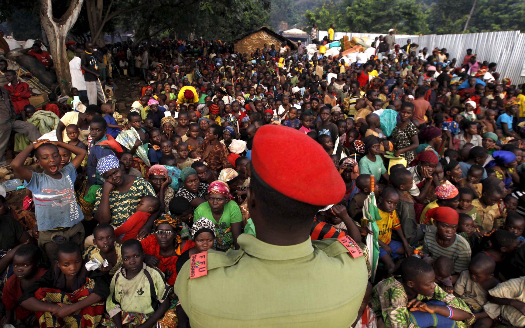 Un policier tanzanien surveille des réfugiés burundais qui se rassemblent sur les rives du lac Tanganyika, dans le village de Kagunga, dans la région de Kigoma, à l’ouest de la Tanzanie, où ils attendent d’être transportés vers la municipalité de Kigoma, 