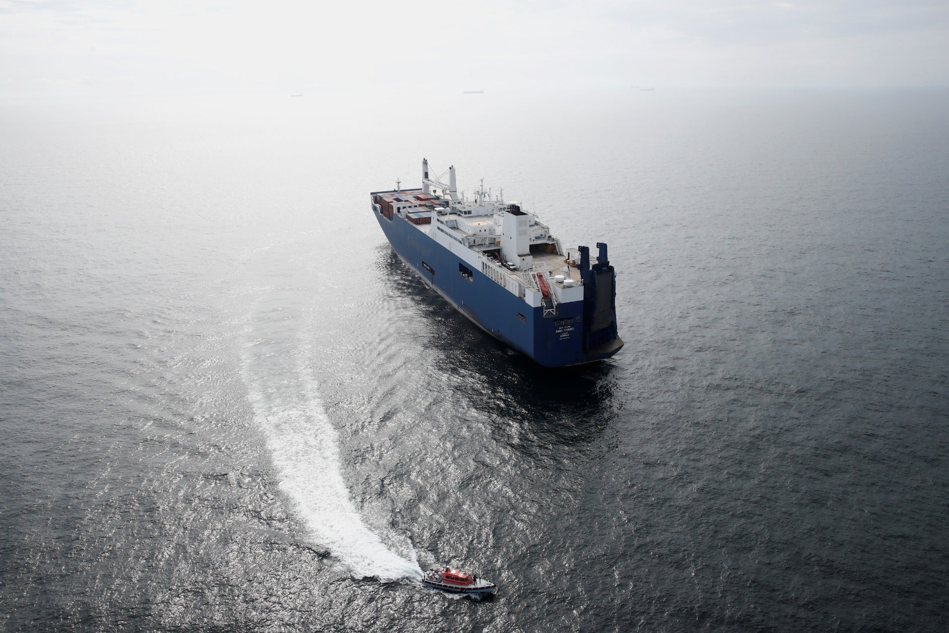 Un patrouilleur français navigue à côté du Bahri-Yanbu, un cargo saoudien qui attend d'entrer dans le port du Havre le 10 mai 2019, alors que des associations de défense des droits humains tentent de bloquer le chargement d'armes sur ce navire.