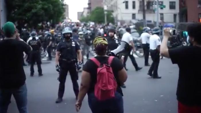 Protester confronted by police line