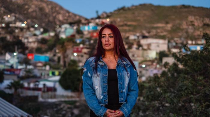 A woman standing in front of a blurred cityscape