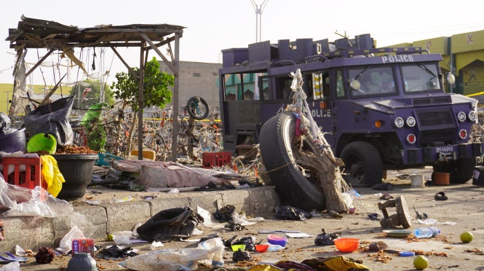 An armored police vehicle at a market in Maiduguri, Nigeria amid debris