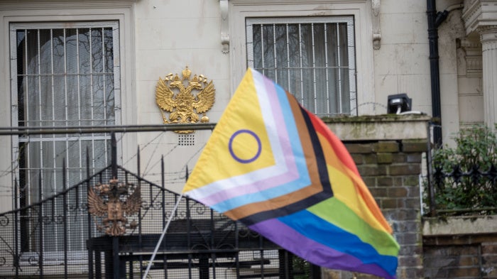 A Pride flag near the Russian coat of arms during a protest outside the Russian embassy in London, March 16, 2023.