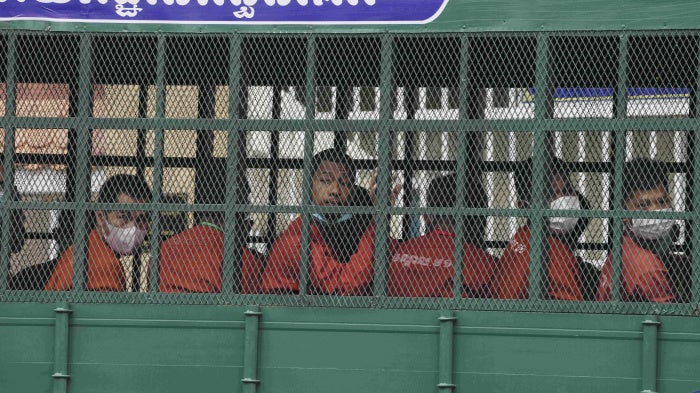 People on a prison truck arrive at the Municipal Court in Phnom Penh, Cambodia, March 17, 2022.