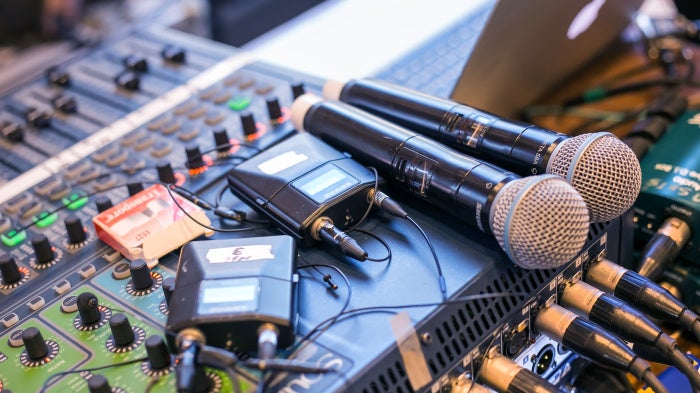 Microphones and receivers on a mixing desk. 