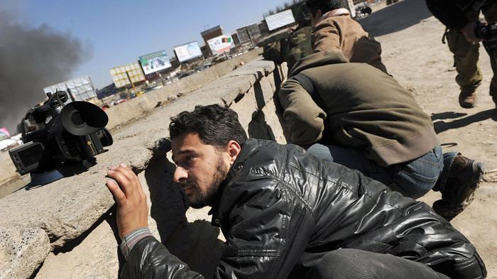 Afghan journalists seek cover in Kabul on Jan. 18, 2010 during a series of co-ordinated attacks by Taliban militants in the Afghan capital that killed at least 10 people and injured 32.