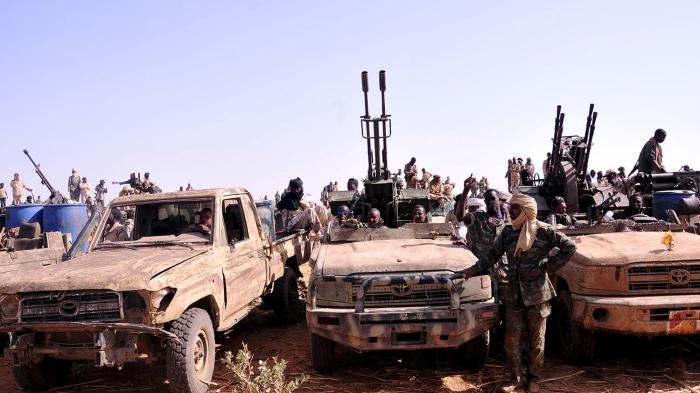 مقاتلون من "قوات الدعم السريع" السودانية في آليات تم الاستيلاء عليها، يحتفلون بالنصر على حركة "العدالة والمساواة" المتمردة في قوز دنقو، جنوب دارفور، 28 أبريل/نيسان 2015