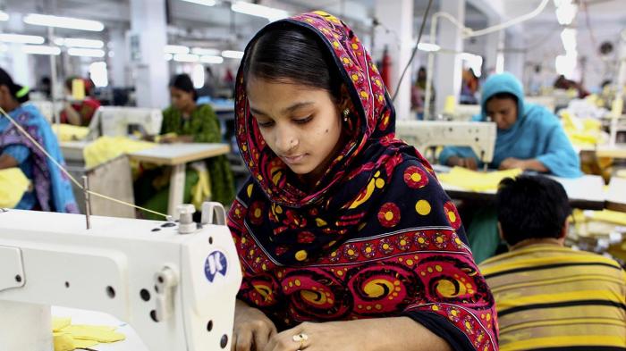 Une ouvrière du textile coud des vêtements dans un bâtiment à proximité du site de l'effondrement de l’immeuble du Rana Plaza, dans la banlieue de Dhaka, au Bangladesh