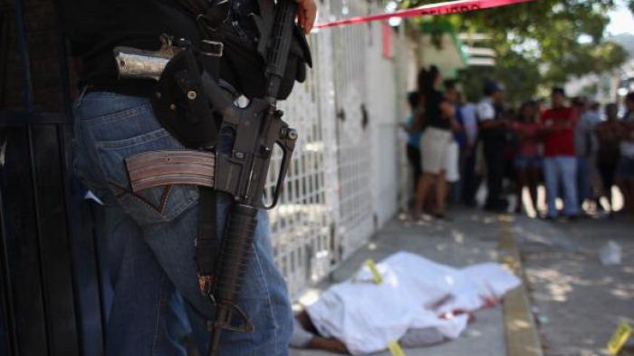 A policeman watches a covered body