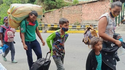 Returnees walking along road carrying belongings
