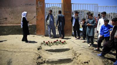 People put flowers outside a school the day after a deadly attack