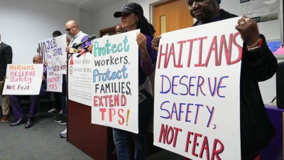 Personas sostienen carteles durante una manifestación en apoyo a la extensión del Estatus de Protección Temporal (TPS, por sus siglas en inglés) para migrantes haitianos, antes de su vencimiento previsto el 3 de febrero, en Fort Lauderdale, Florida, el miércoles 28 de enero de 2026. 