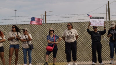 Manifestantes que se oponen a las deportaciones masivas del ICE sostienen pancartas durante una protesta frente a Fort Bliss
