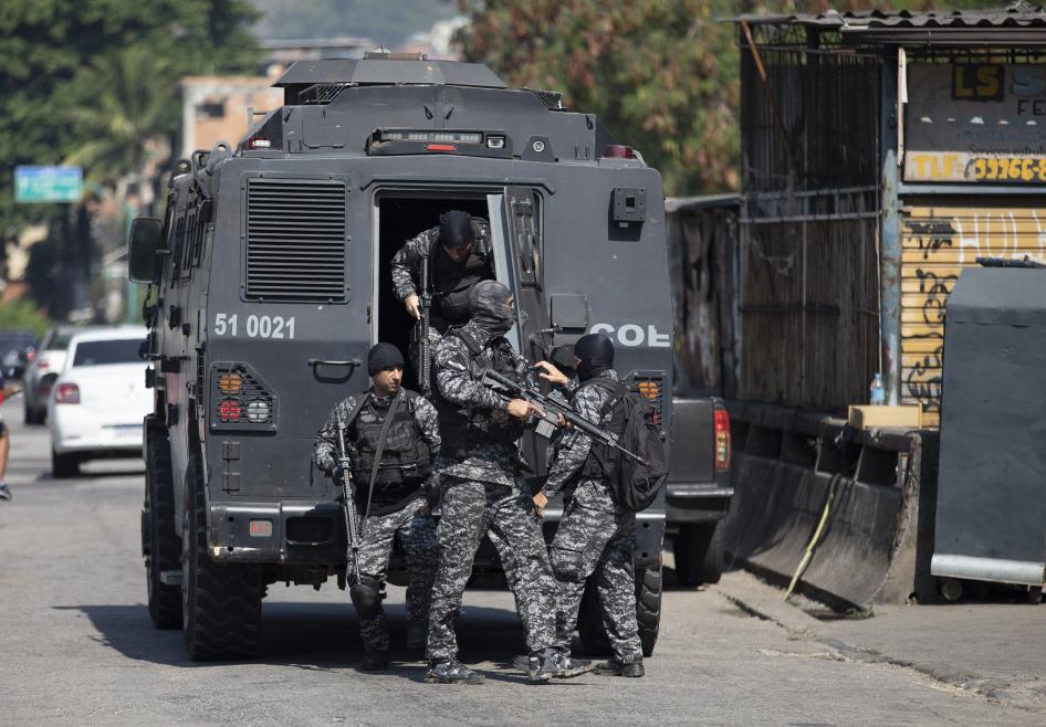 Policiais fortemente armados saem de um veículo blindado durante uma operação em 6 de maio de 2021 na comunidade Jacarezinho, no Rio de Janeiro, Brasil.