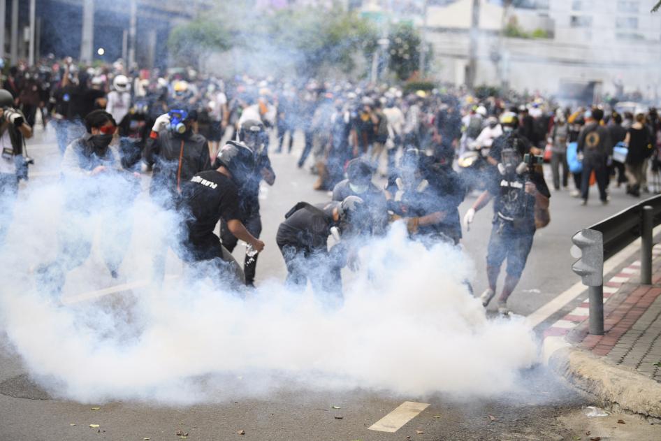 A crowd of protestors amongst teargas 