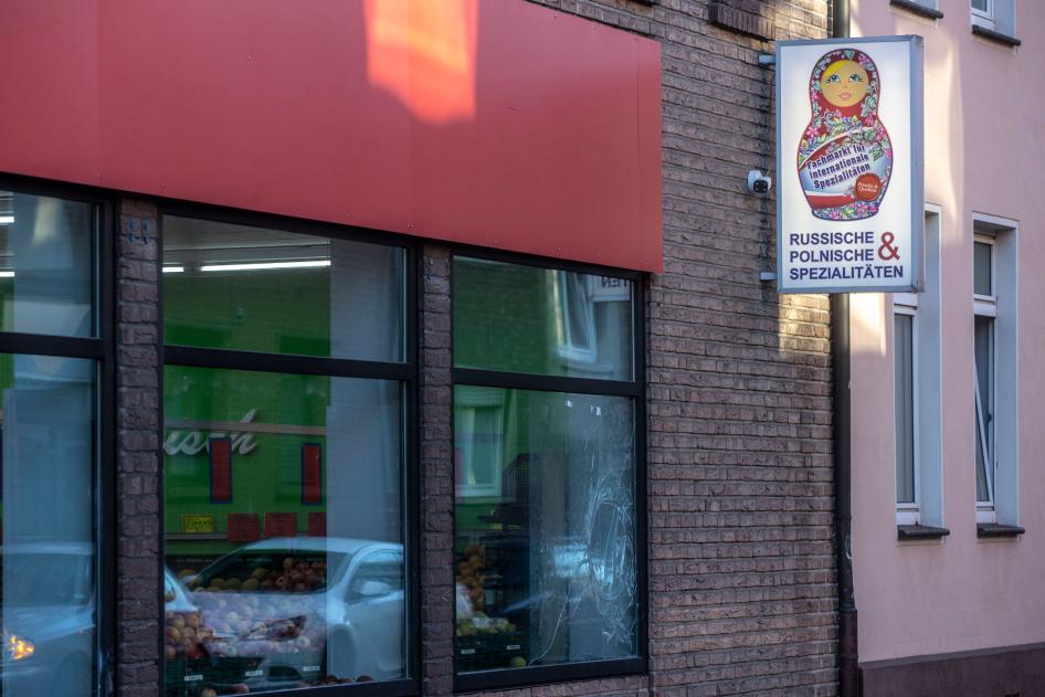A smashed window pane and smeared white paint are seen on a Russian-Polish supermarket