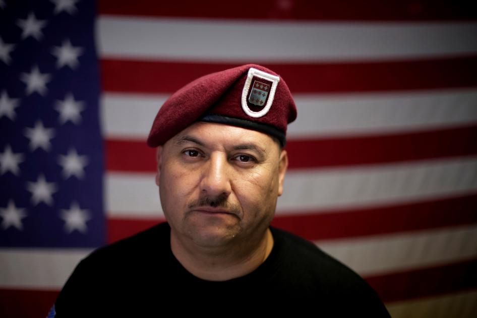 A man poses for a photo in front of an American flag