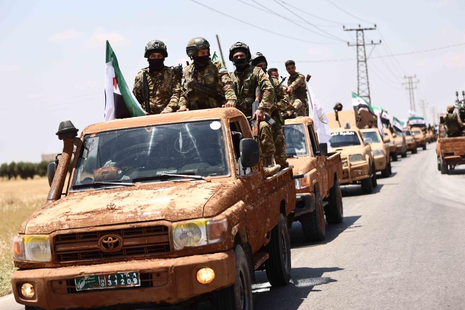 Çekdarên Artêşa Niştimanî ya Sûriyê, ku Tirkiye piştgiriya wê dike, beşdarî merasîmeke leşkerî li gundewarê parêzgeha Helebê dibin di 9ê Hezîrana 2022an de, di çarçoveya amadekariyên wê hêzê de ji bo çalakiyên leşkerî li ser deverên di bin kontrola Hêzên Sûriya Demokratîk de.