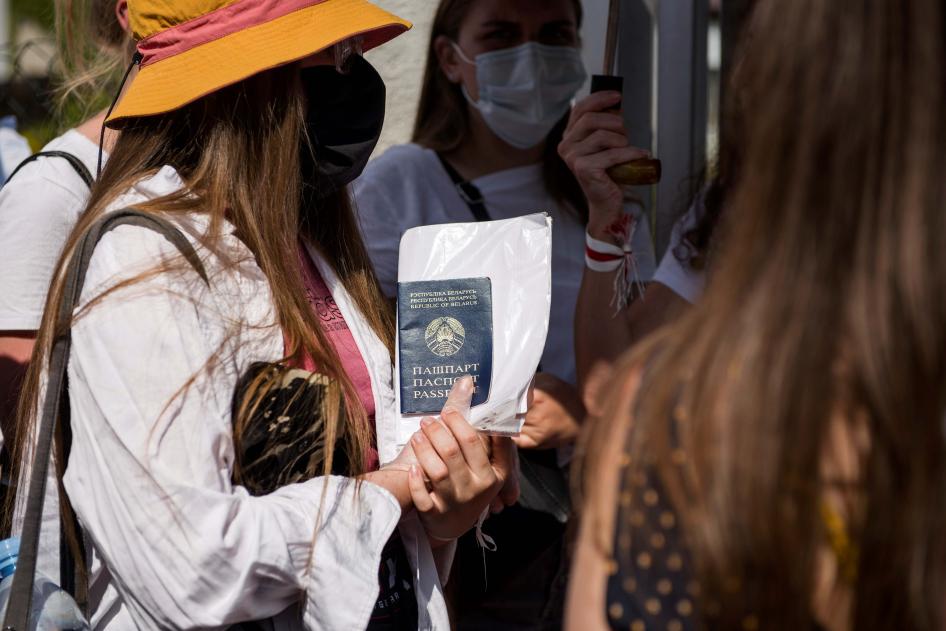 Белорусская женщина держит свой паспорт перед зданием посольства Беларуси в Варшаве, Польша, 9 августа 2020 г.