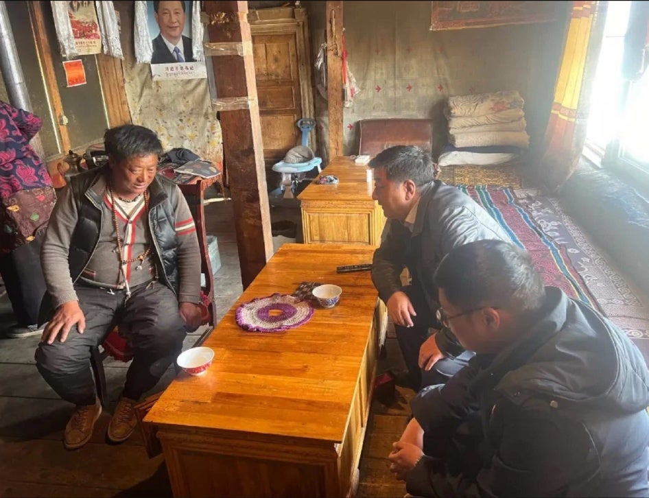 Two men speaking with another man in a house