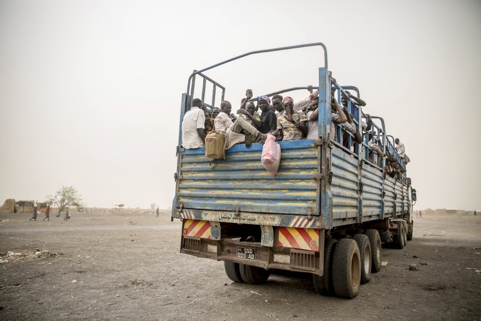 Des réfugiés sont transportés dans des camions 
