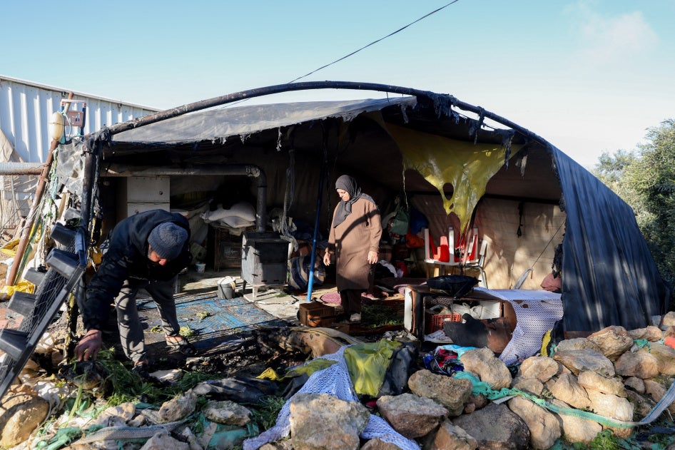 תושבים בוחנים רכוש שניזוק בתוך אוהל ששרפו אנשים החשודים כמתנחלים ישראלים בכפר ח'ירבת סוסיא במסאפר יטא שמדרום לחברון, בגדה המערבית הכבושה בידי ישראל, 25 בפברואר 2026.
