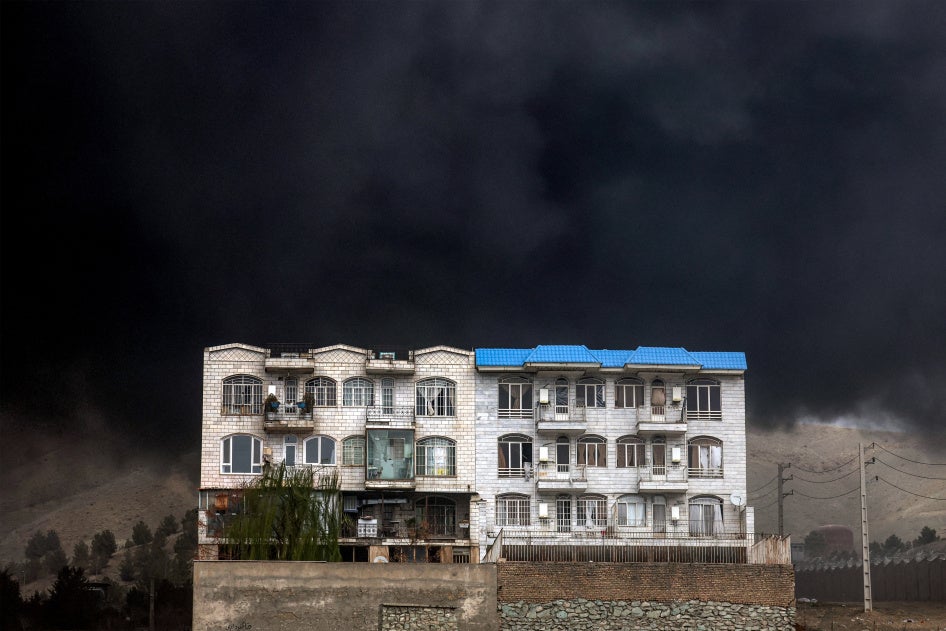 Un gigantesque écran de fumée noire était visible derrière un immeuble résidentiel dans la banlieue nord-ouest de Téhéran, en Iran, le 8 mars 2026, à la suite de frappes aériennes israéliennes menées le 7 mars contre la raffinerie de pétrole de Shahran, non loin de là.