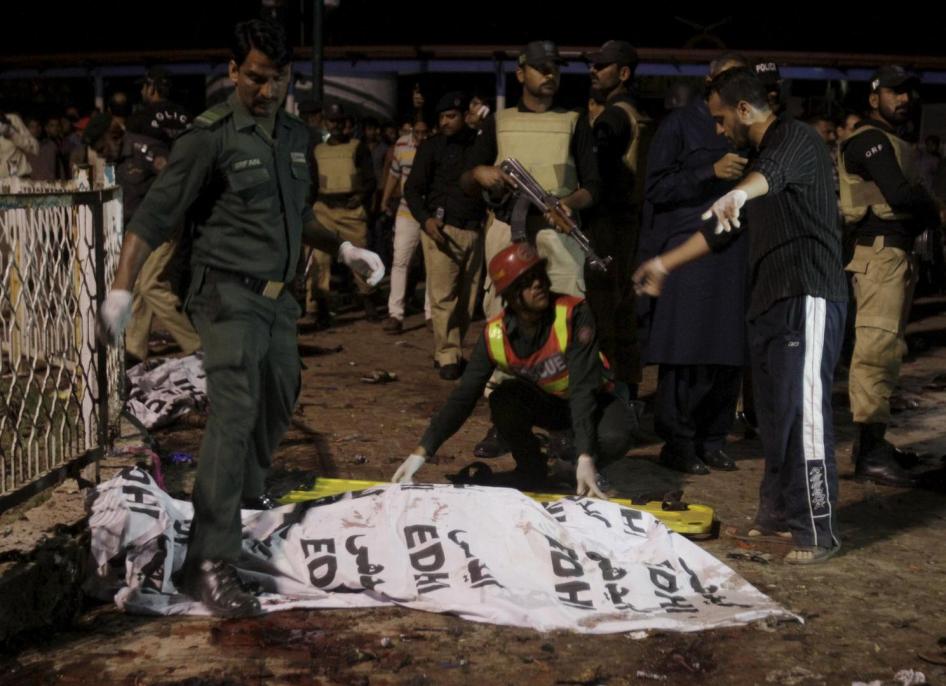Rescue workers move a body from the site of a blast outside a public park in Lahore, Pakistan on March 27, 2016.