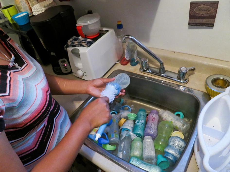 Roxanne Moonias, mother to an infant with a chronic illness, demonstrates one of the steps she takes to ensure her baby is not exposed to contaminants in the water. Roxanne lives in Neskantaga First Nation and says that it takes her an hour each time to p