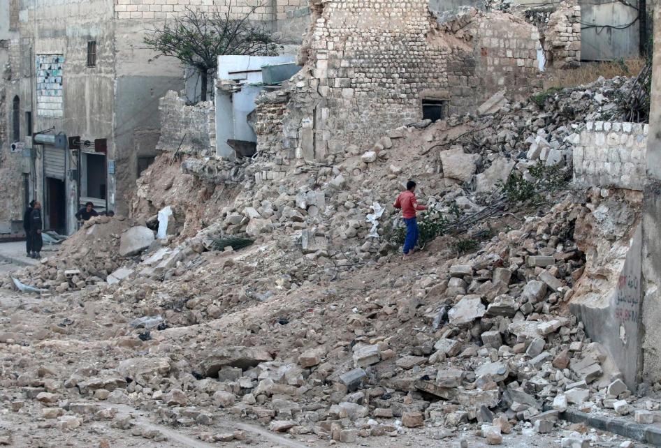 مدني يجمع أغصان أشجار من بين الركام في موقع مدمر في حي قاضي عسكر في الجزء المحاصر الذي تسيطر عليه المعارضة.