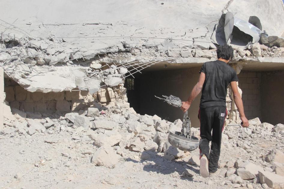 A man carries what appears to be a remnant of the parachute system of one of the bombs used in the attack on a school complex in al-Hass on October 26.