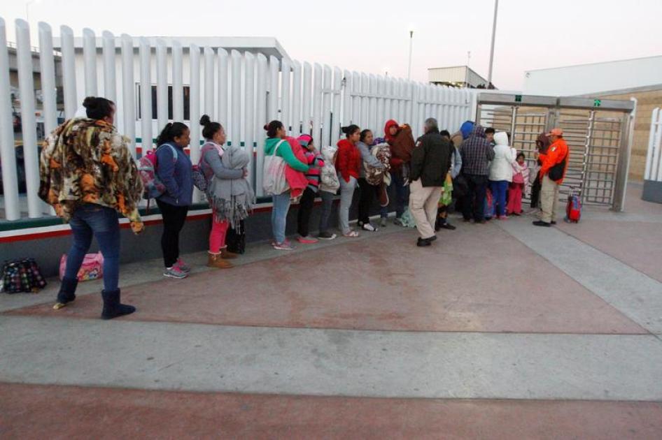 Immigrants from Central America and Mexican citizens, who are fleeing from violence and poverty, queue to cross into the U.S. to apply for asylum.