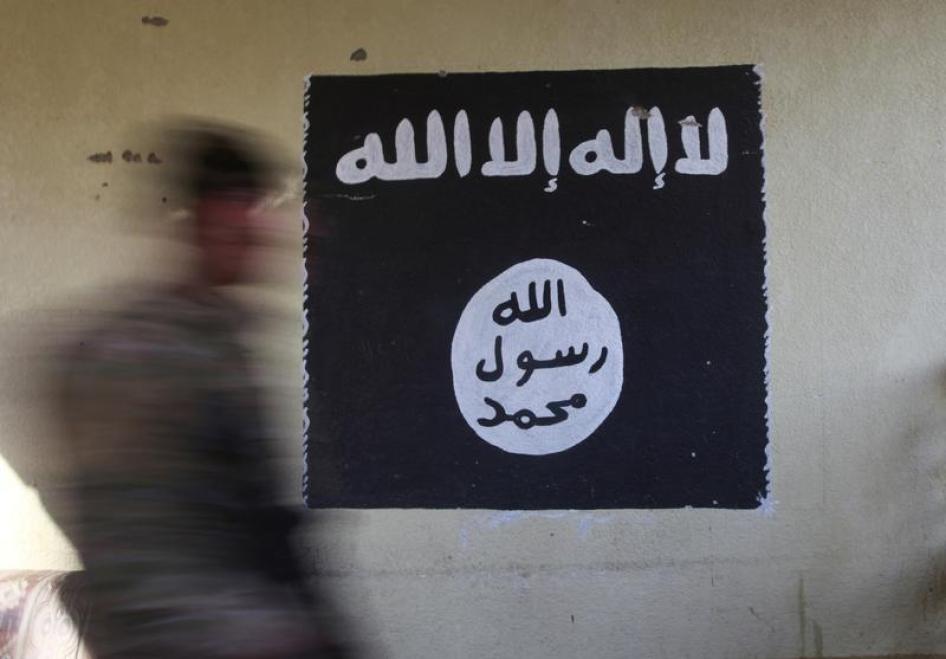 A member of the Iraqi security forces walks past a wall painted with the black flag commonly used by ISIS in Mosul, Iraq, January 8, 2017. © 2017 Reuters