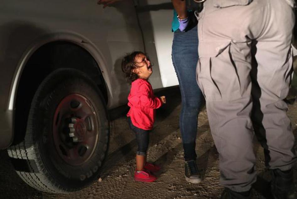 Pencari suaka berumur dua tahun asal Honduras menangis ketika ibunya digeledah dan ditahan dekat perbatasan AS-Meksiko pada 12 Juni 2018, di McAllen, Texas. Badan Bea Cukai dan Perlindungan Perbatasan Amerika Serikat (CBP) menjalankan kebijakan 'nol toler