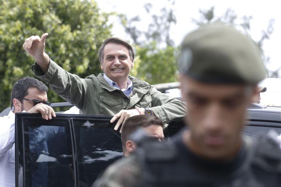 Protected by Federal Police agents, Social Liberal Party (PSL) presidential candidate Jair Bolsonaro votes on October 28 at the Rosa da Fonseca Municipal School in Rio de Janeiro, Brazil.