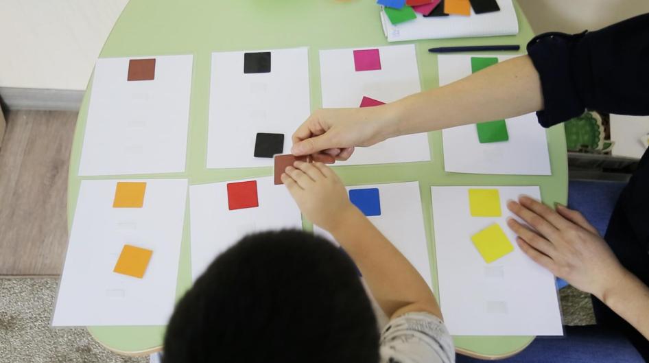 A special education teacher and a child with autism match squares at Balama Center, an organization that offers support to children with autism in Almaty, Kazakhstan. 
