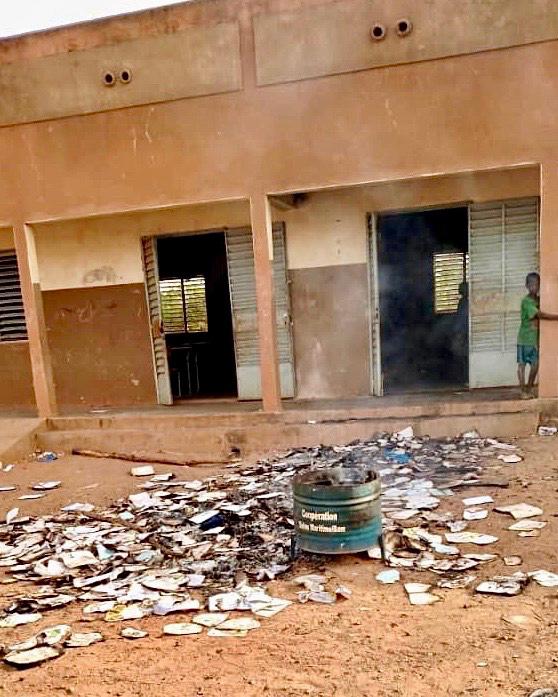 Burned books outside of a damaged school building
