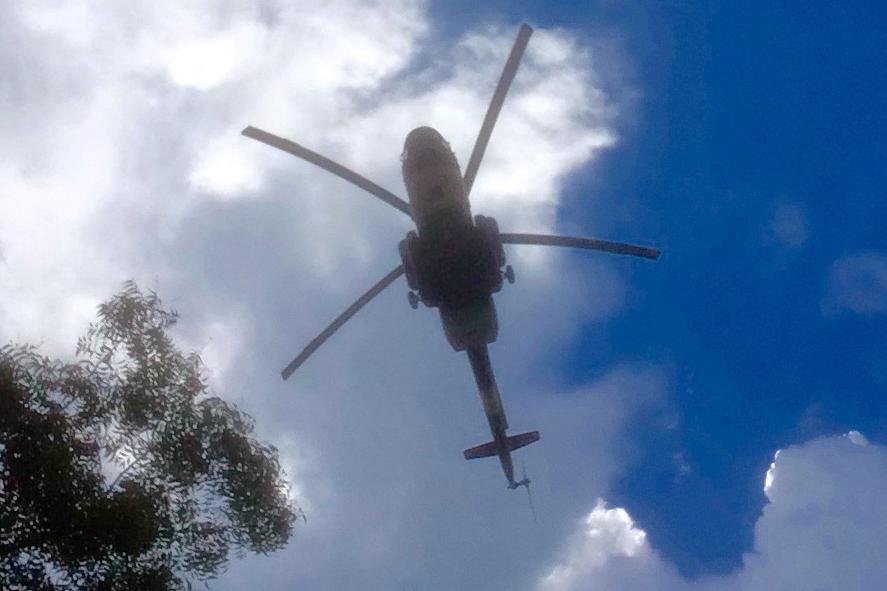 Government helicopter gunship flying low over IDP site at the UN base in Thongpiny, Juba, South Sudan. 