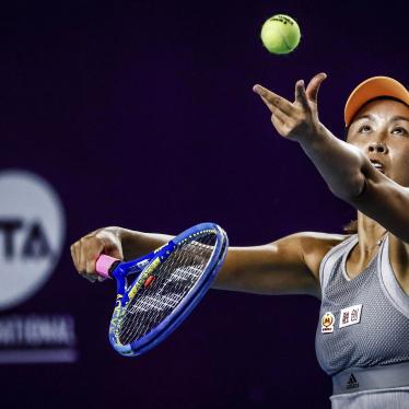 A woman in athletic wear holding a tennis racket 