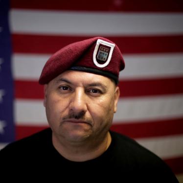 A man poses for a photo in front of an American flag