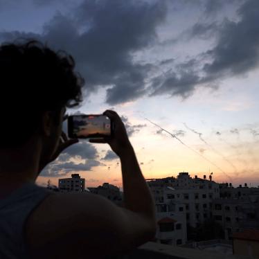 A man records a video with his mobile phone of rockets being fired