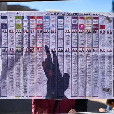A woman points on the list of candidates placed outside a polling station during legislative midterm elections in Buenos Aires, Argentina, October 26, 2025.