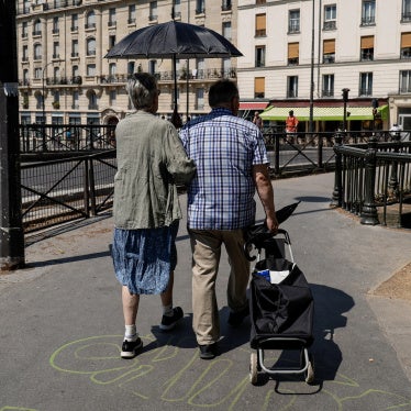 An older couple shelters from the sun under an umbrella near the Canal Saint-Martin in Paris, Ile-de-France, France, on June 26, 2026. 